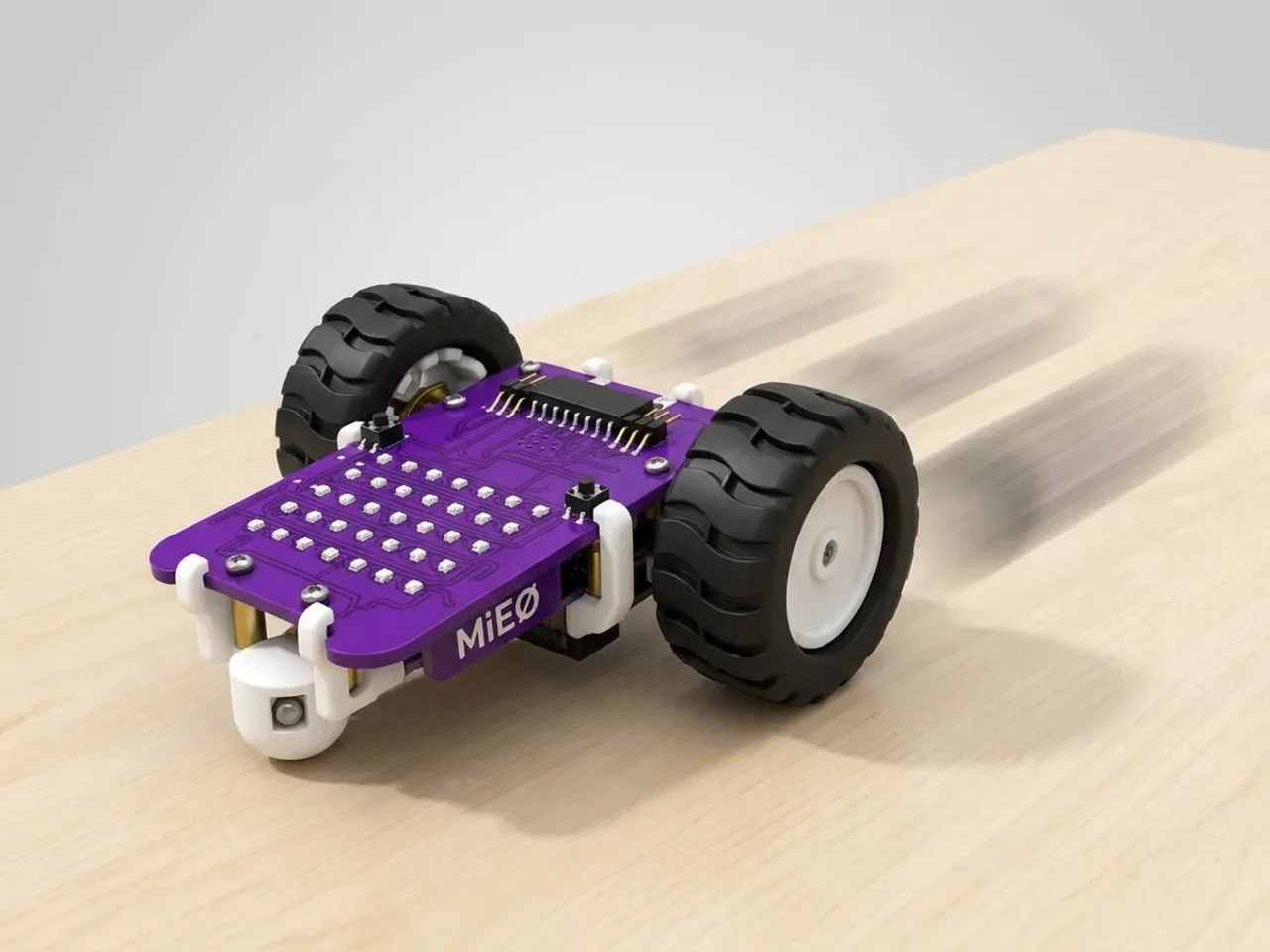 Two-wheel MIEO speeding along a desk with three speed arrows behind it