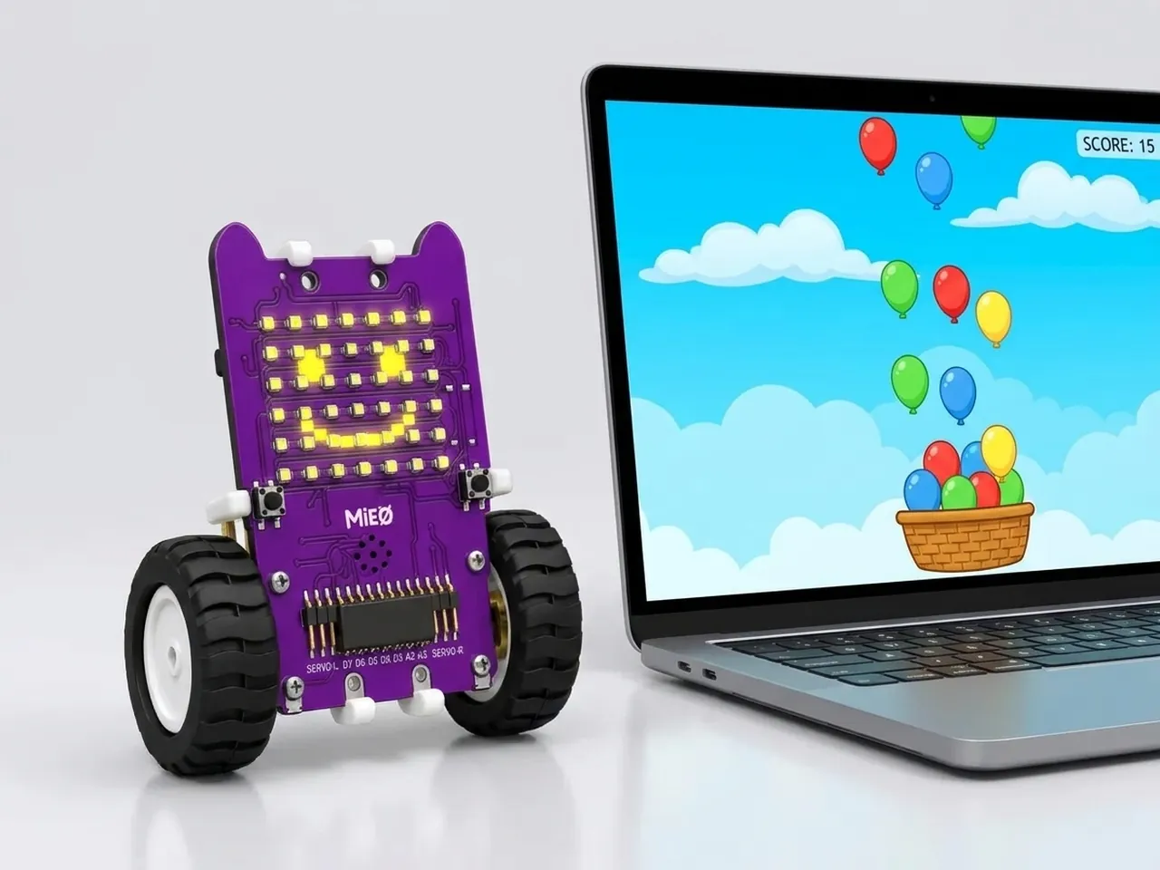 MIEO with a smiling LED face beside a laptop running a balloon catching game