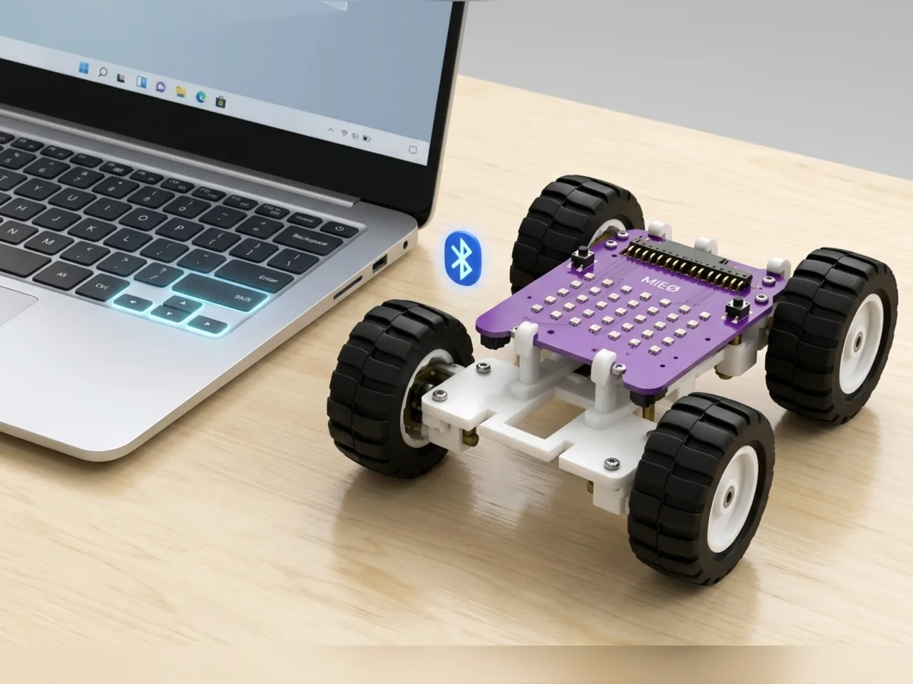 Four-wheel MIEO driving across a desk while a laptop's arrow keys glow