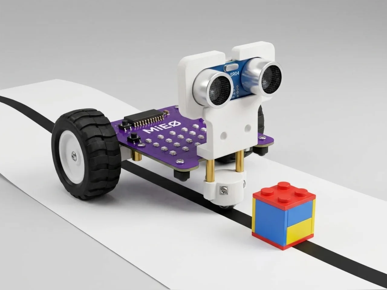 MIEO following a black line and stopping in front of a toy block on the track
