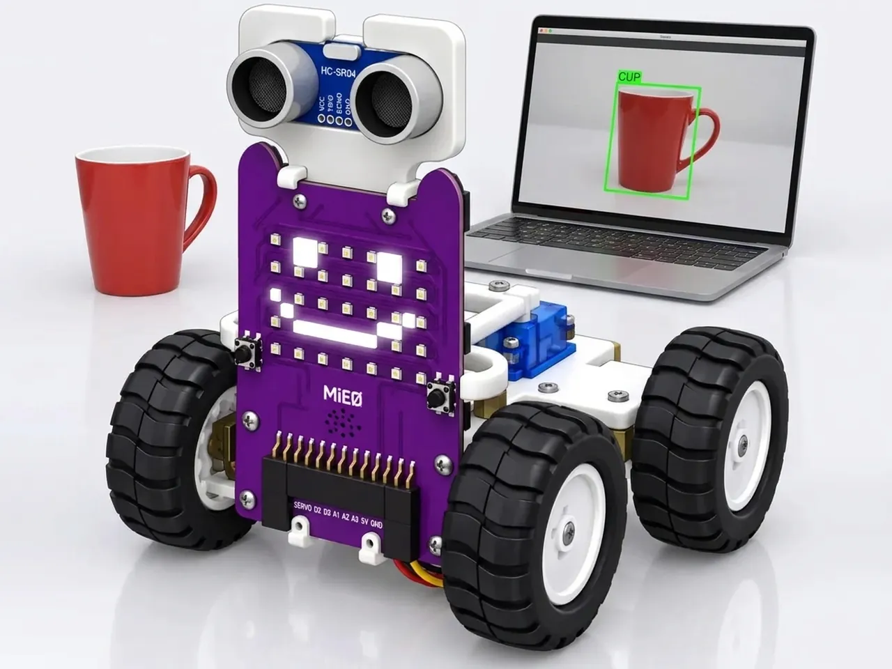 Four-wheel MIEO with a happy LED face beside a red cup the laptop has labelled cup